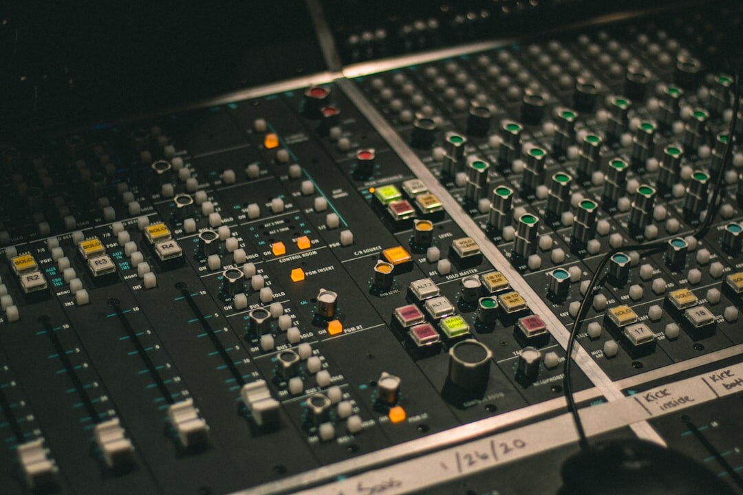 Audio mixing console with sliders and headphones in a sound studio